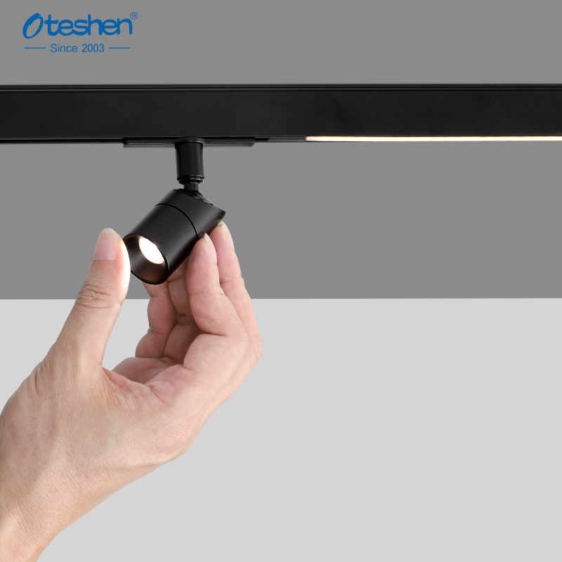 Alt: Hand installing cylinder magnetic spot light onto magnetic track system demonstration Alt: магниттік жол жүйесінің демонстрациясына цилиндрлік магниттік нүктелік шамды қолмен орнату
