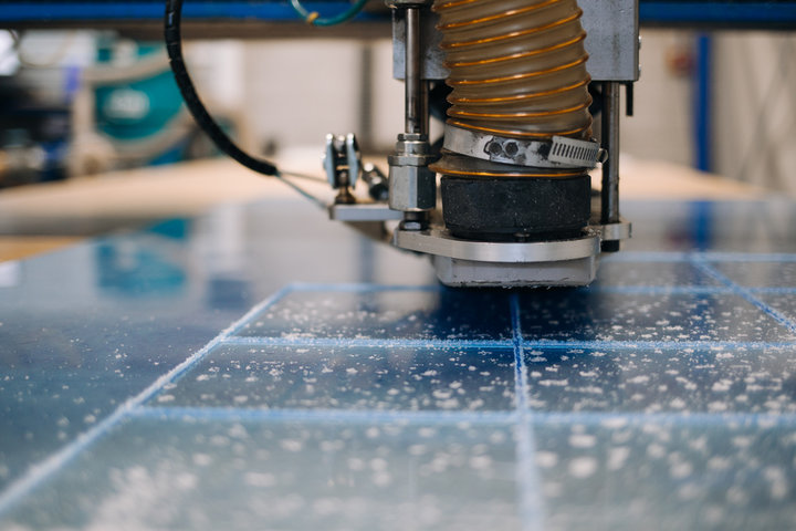 Cutter tat-tħin jaqta 'parti tal-plastik fuq linja ta' produzzjoni robotizzata