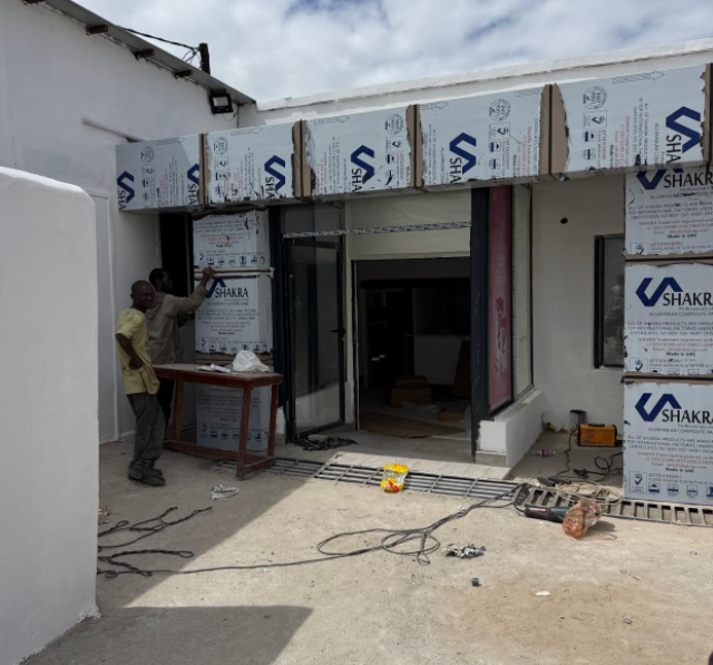Cantiere esterno di una struttura clinica medica di nuova costruzione in Zambia, che mostra la fase di installazione dell'ingresso dell'edificio.