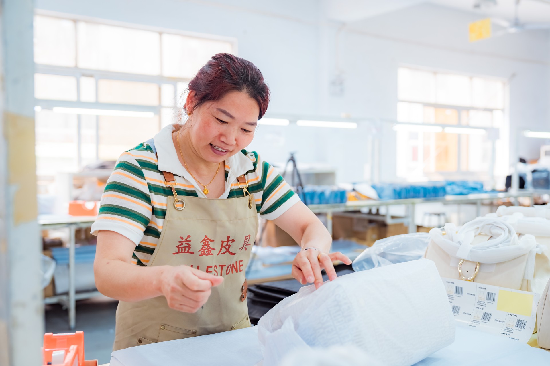 Guangzhou luxury bag atelier interior with artisans working